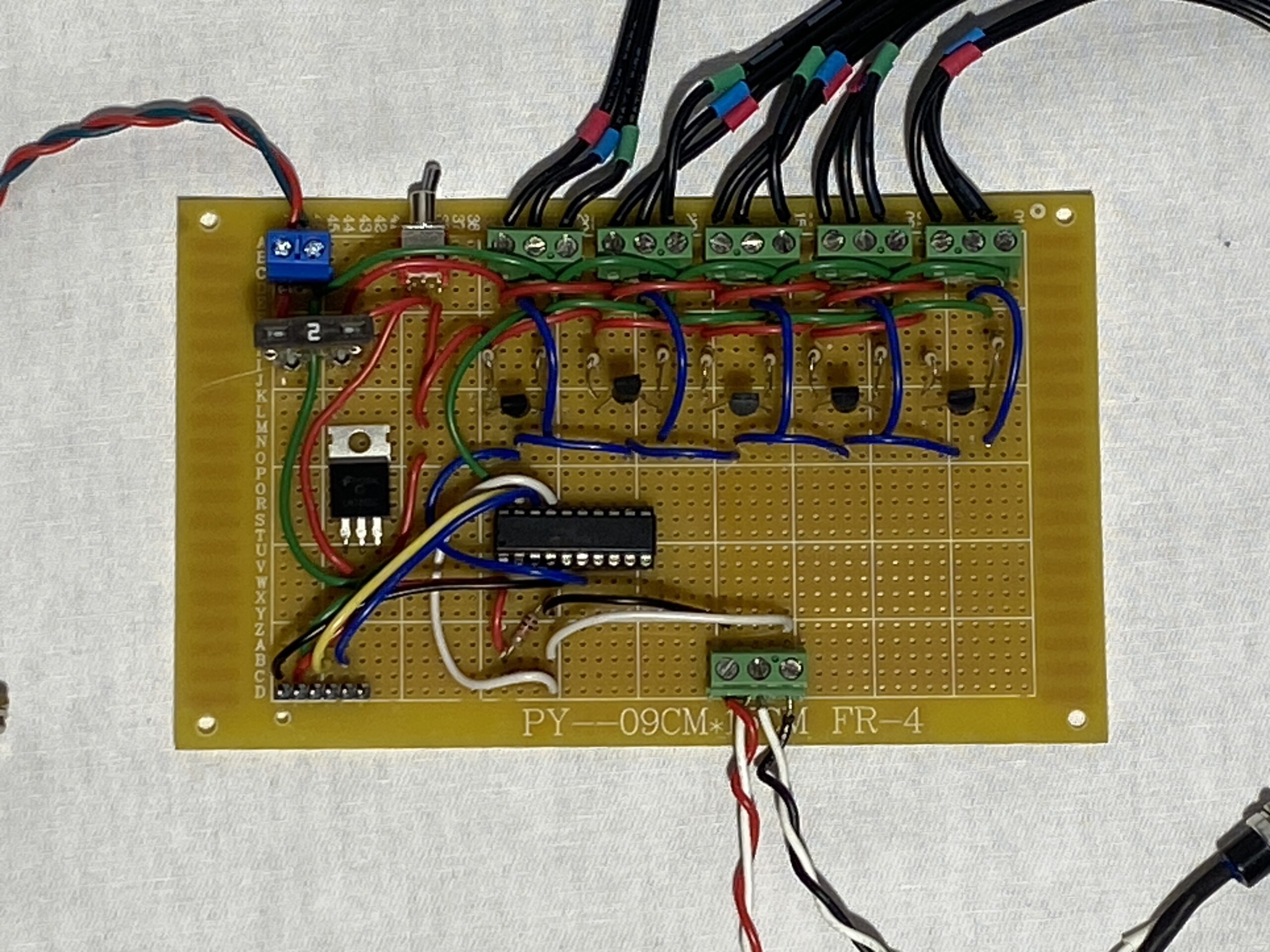 Custom electronic circuit board with multiple buttons and wiring connections.